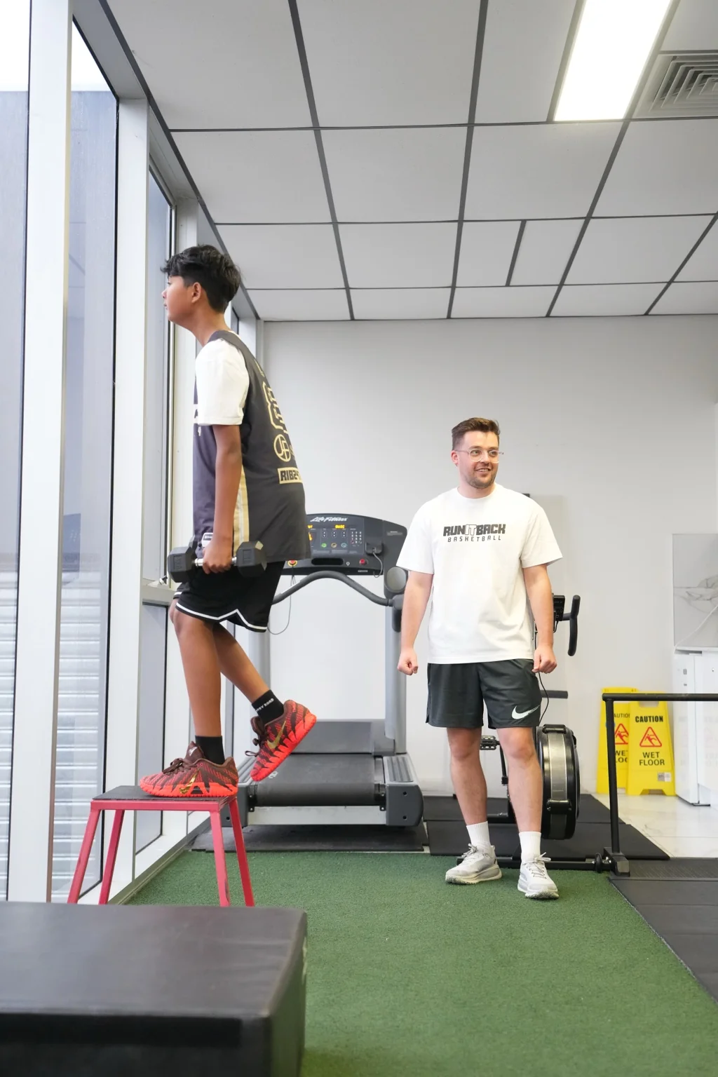 Arie supervising an athlete performing a weighted step-up