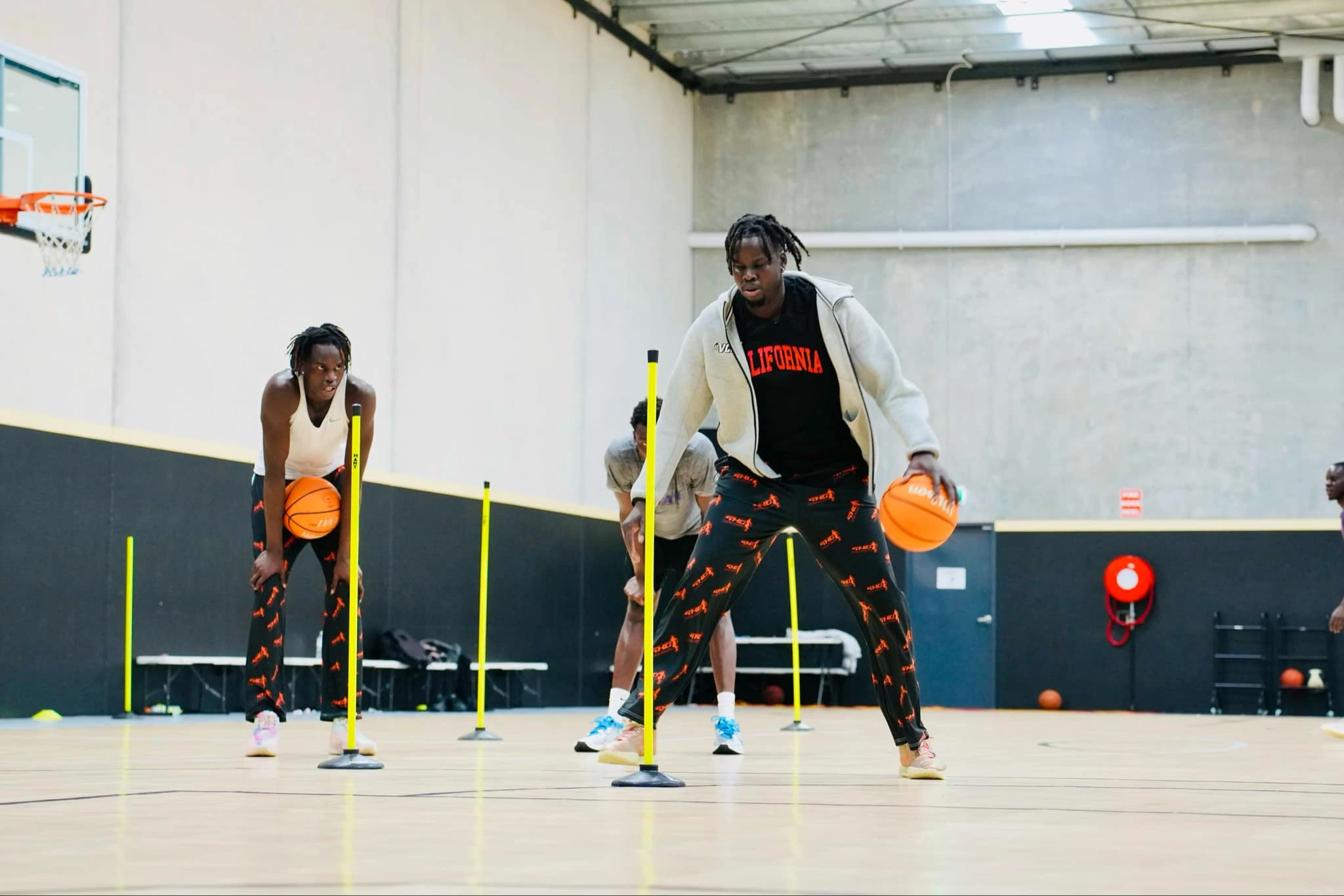 Basketball athletes practising dribbling drills on an indoor court